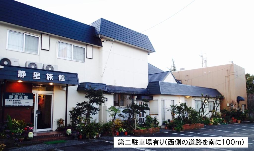 un bâtiment blanc avec des écritures sur son côté dans l'établissement Business Hotel Shizusato Ryokan, à Ōgaki
