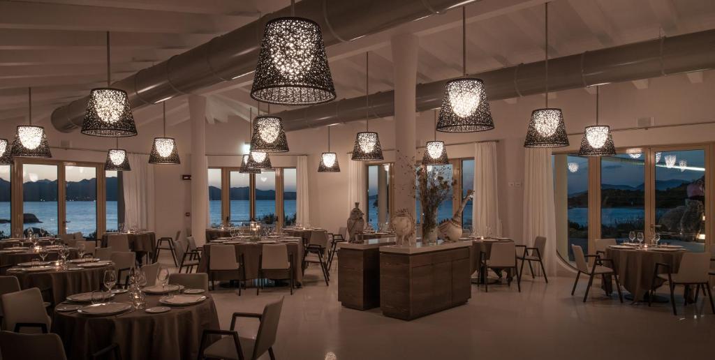 - une salle de banquet avec des tables, des chaises et des lumières dans l'établissement Cala Cuncheddi - VRetreats, à Murta Maria
