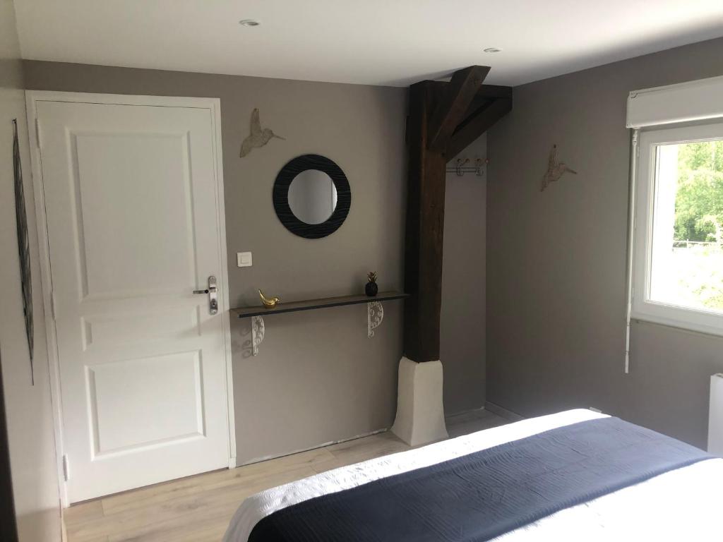 - une chambre avec une porte blanche et un miroir dans l'établissement Gîte le P'ti bonheur, à Les Préaux