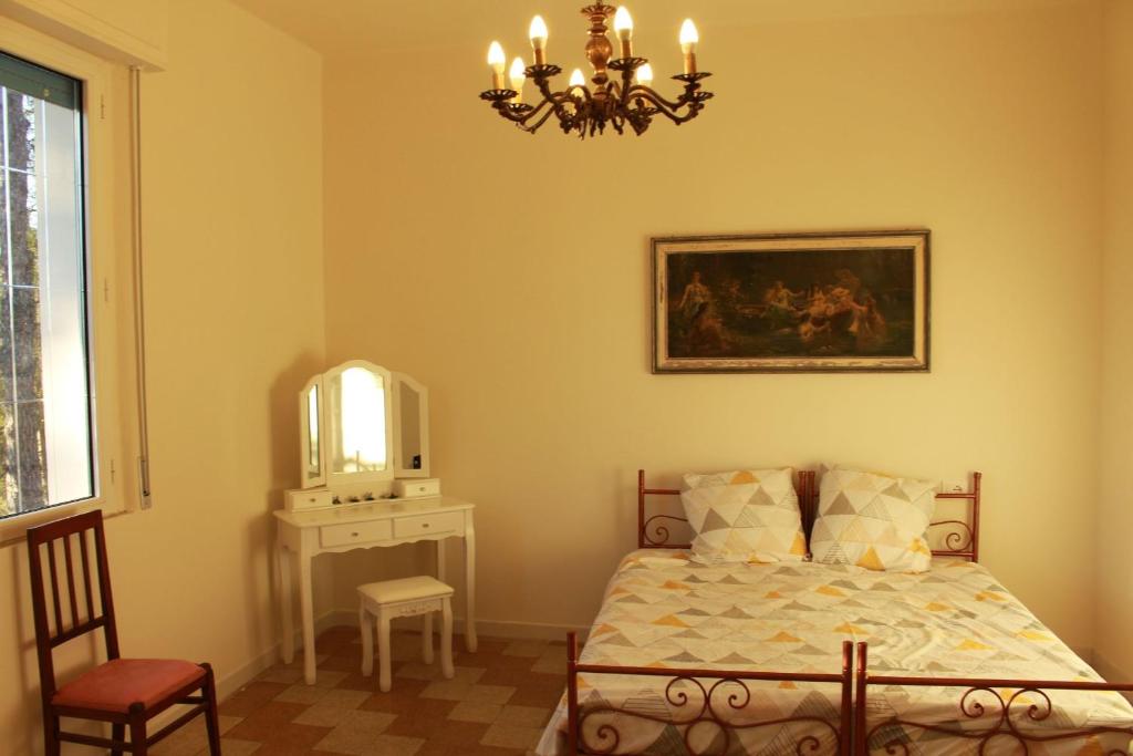 - une chambre avec un lit, un miroir et un lustre dans l'établissement Villa La Casa Bianca, à Podere Pian Mucini