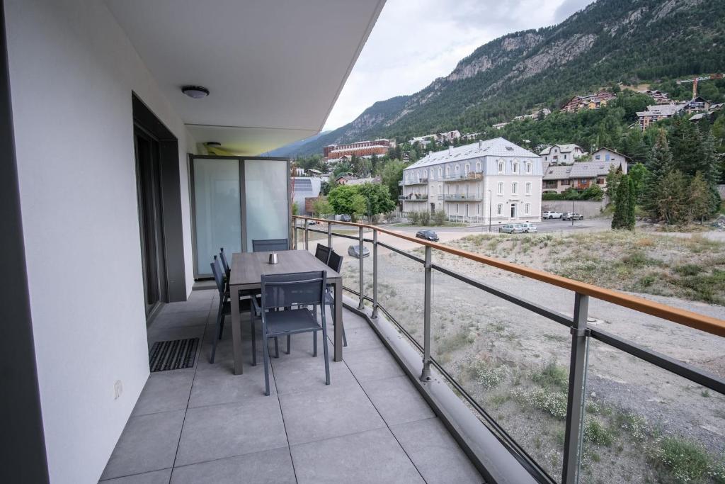 un balcon avec une table et des chaises et une vue dans l'établissement SUPERB apt with BALCONY in BRIANÇON, à Briançon