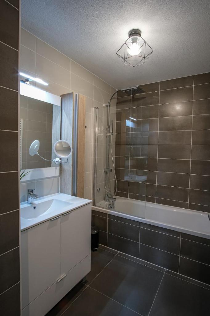 une salle de bain avec un lavabo, une baignoire et une douche dans l'établissement SUPERB apt with BALCONY in BRIANÇON, à Briançon 13 autres photos