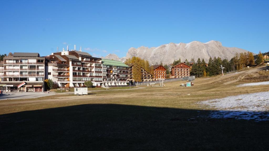 - une vue sur un complexe avec des montagnes en arrière-plan dans l'établissement LA JOUE DU LOUP STUDIO, à La Joue du Loup