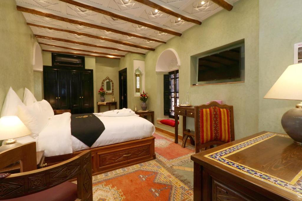 Cet appartement comprend une chambre avec un lit et un salon avec une table. dans l'établissement Riad Omara al Kasbah, à Marrakech