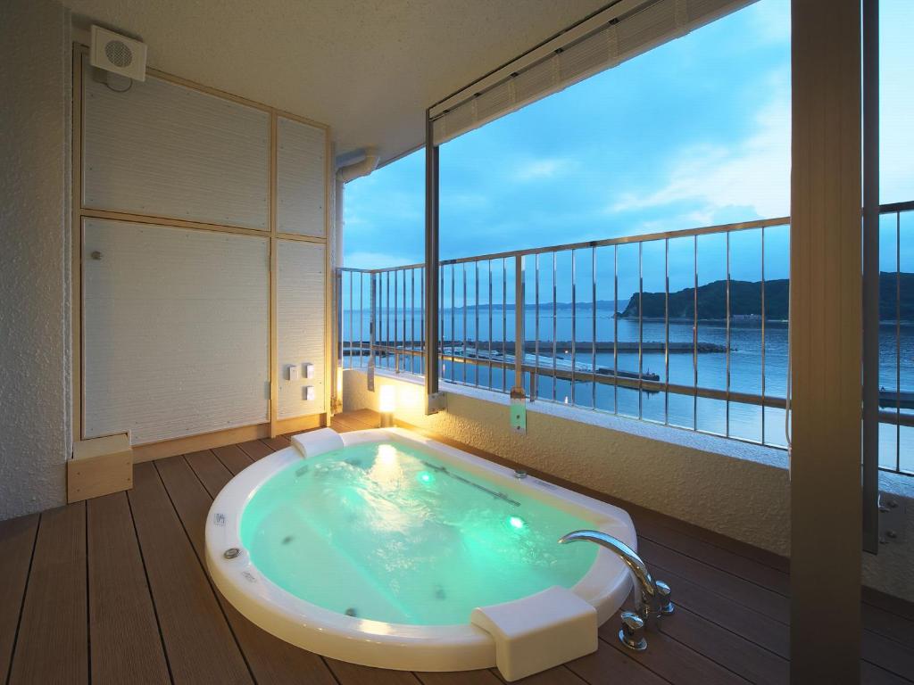 Cette chambre dispose d'une baignoire et offre une vue sur l'océan. dans l'établissement Kichimu, à Kamogawa