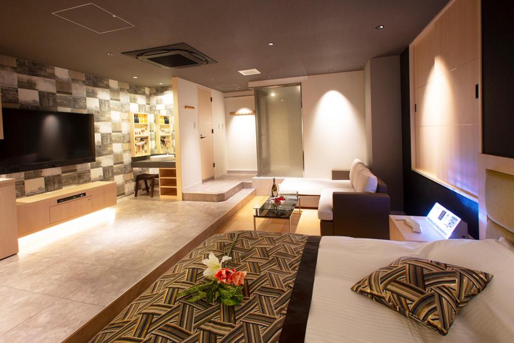une chambre d'hôtel avec un lit et un salon dans l'établissement HOTEL MYTH-CLUB -ホテル マイス クラブ- Adult Only, à Kyoto