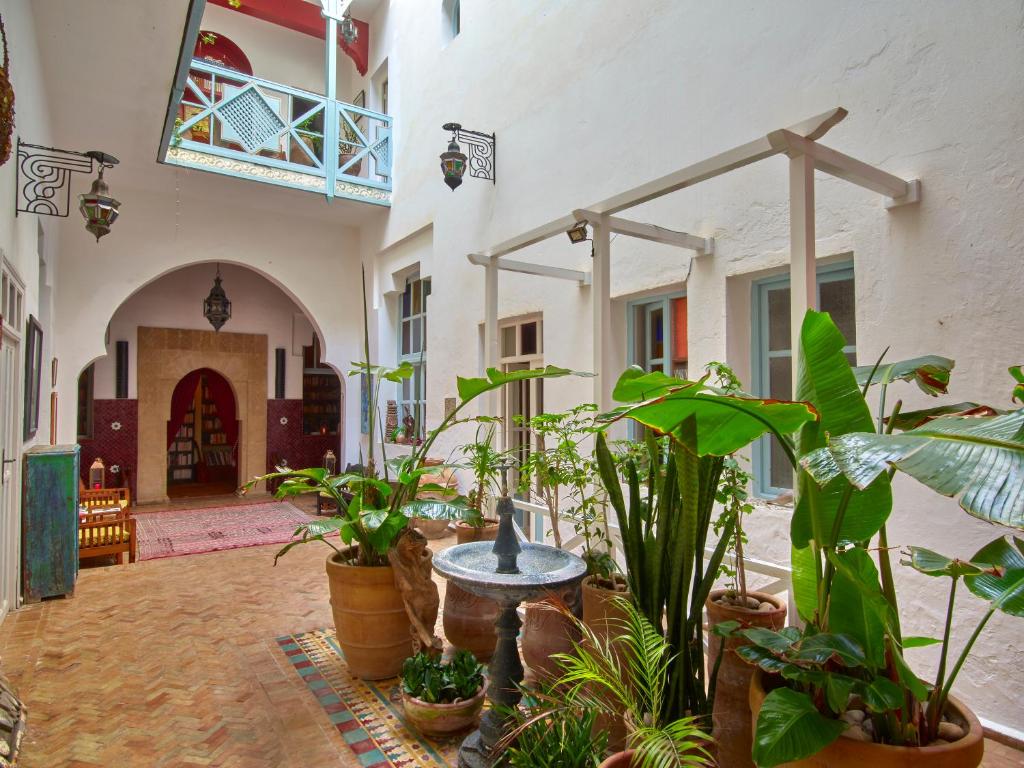 une cour avec des plantes et une fontaine dans un bâtiment dans l'établissement Ryad Watier & SPA, à Essaouira