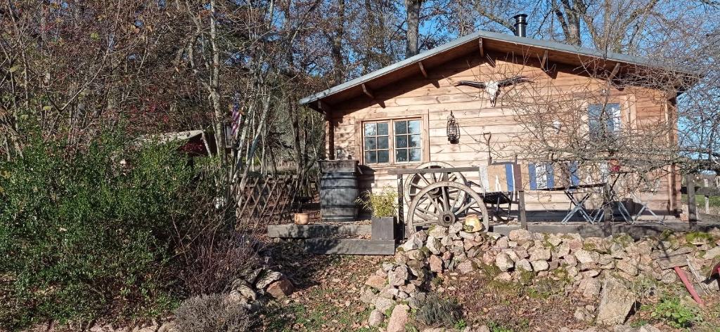 une petite cabane en bois avec un mur en pierre devant elle dans l'établissement Cabanes Nature Morvan, à Blanot