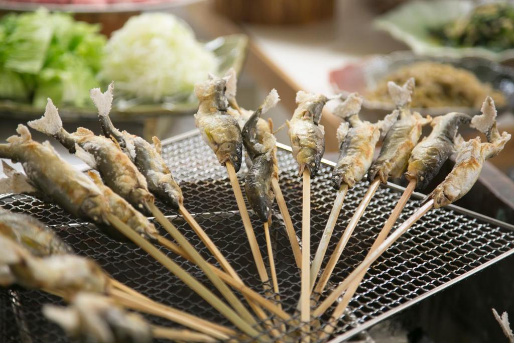 un paquet de bâtons de nourriture sur un grill dans l'établissement Sansuikan Kawayu Midoriya, à Hongu
