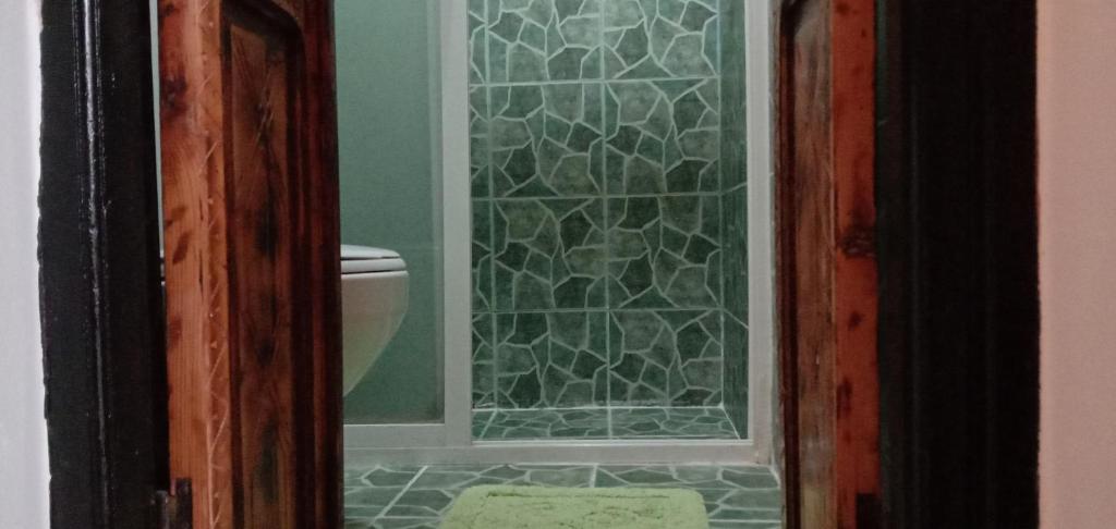 La salle de bains est pourvue de toilettes et d'une porte de douche en verre. dans l'établissement Riad Bab Essaouira, à Essaouira 37 autres photos