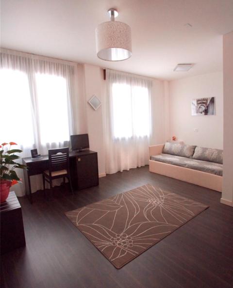 un grand salon avec un canapé et un bureau dans l'établissement Hotel Giulio Cesare, à Rimini