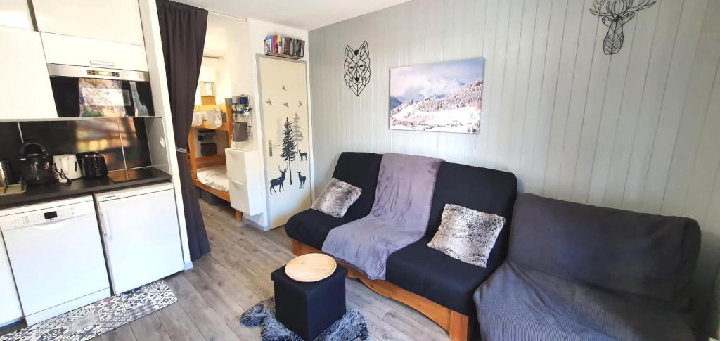 un salon avec un canapé et une cuisine dans l'établissement Studio 2 alpes, proche lac buissonnière, ménage inclus, balcon, parking, à Les Deux Alpes