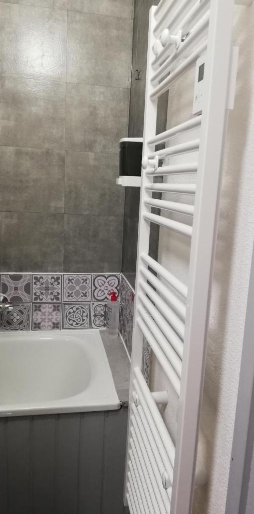 La salle de bains est pourvue d'une baignoire et d'un réfrigérateur blanc. dans l'établissement Studio 2 alpes, proche lac buissonnière, ménage inclus, balcon, parking, à Les Deux Alpes 37 autres photos