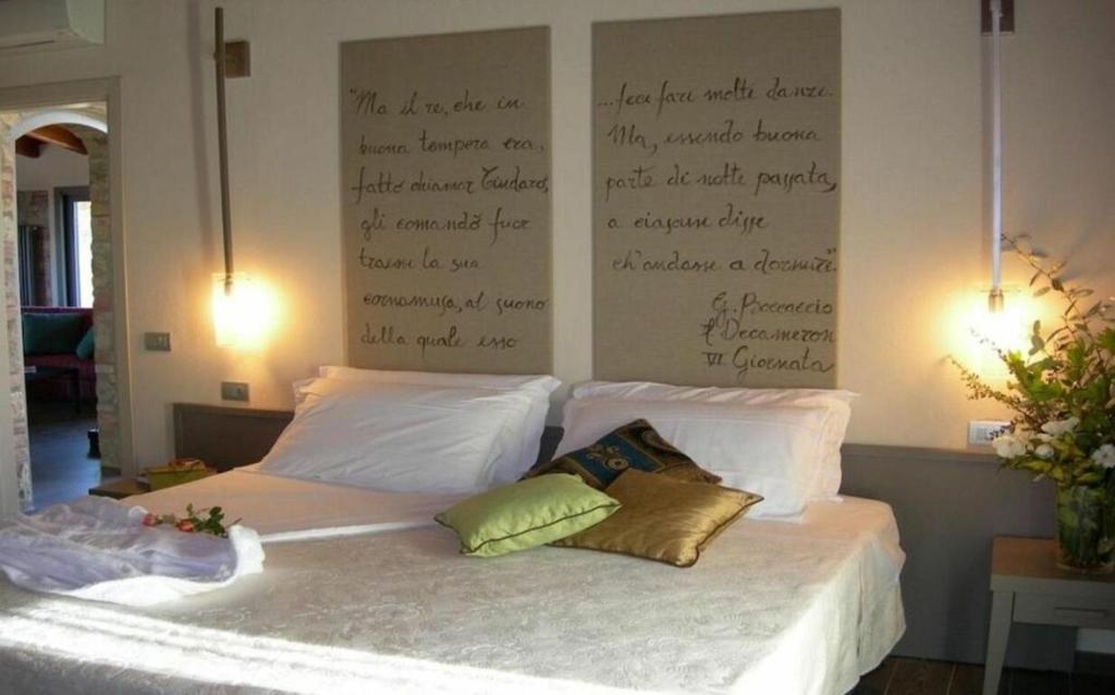 - un lit avec 2 oreillers et un bureau sur le mur dans l'établissement Villa La Tabaccaia by Halldis, à Montaione