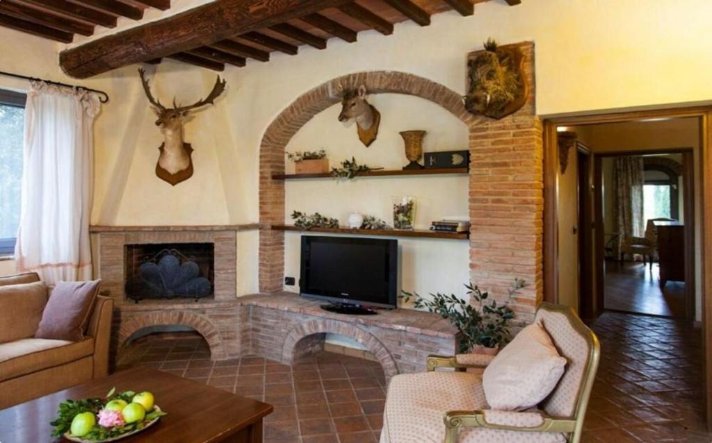 un salon avec une cheminée et une télévision dans l'établissement Villa Cerretello 22 by Halldis, à Montaione