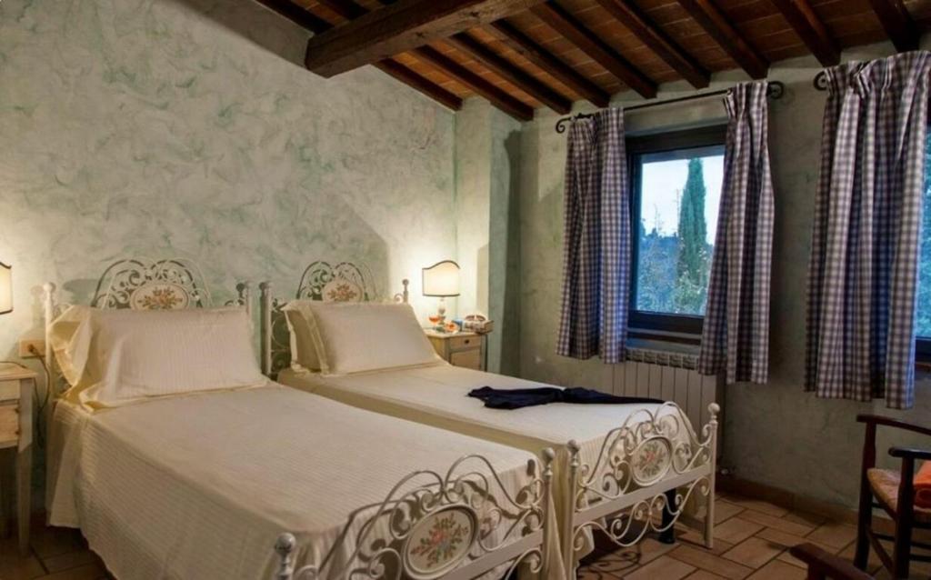 une chambre avec un lit blanc et une fenêtre dans l'établissement Villa Cerretello 22 by Halldis, à Montaione