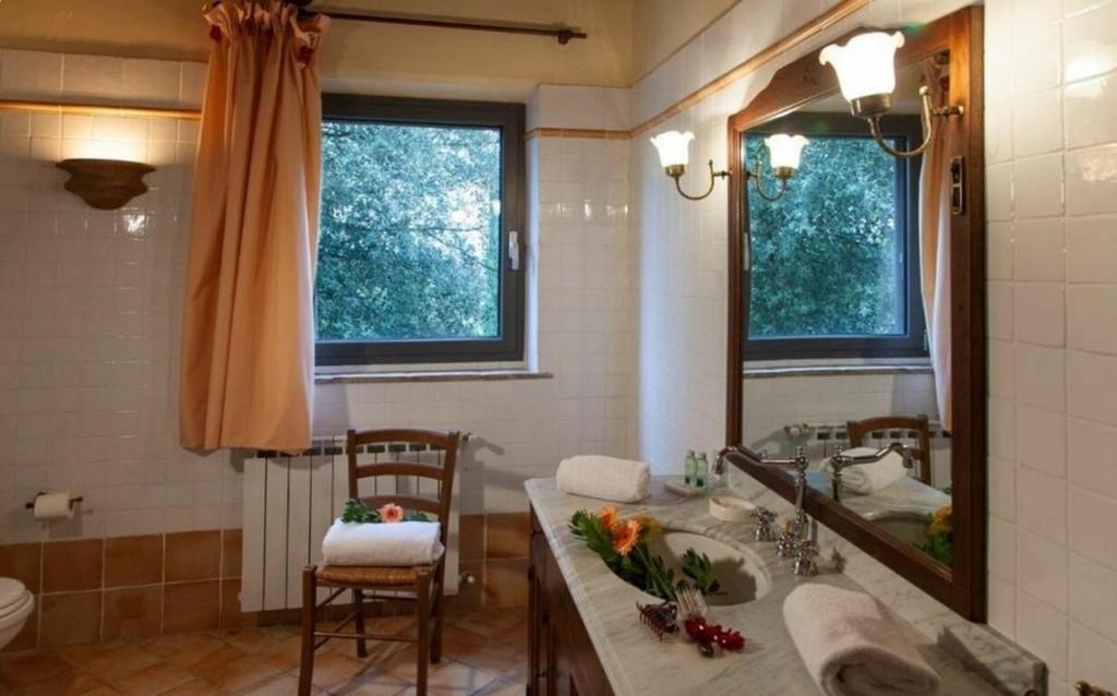 une salle de bain avec un lavabo et un miroir dans l'établissement Villa Cerretello 22 by Halldis, à Montaione