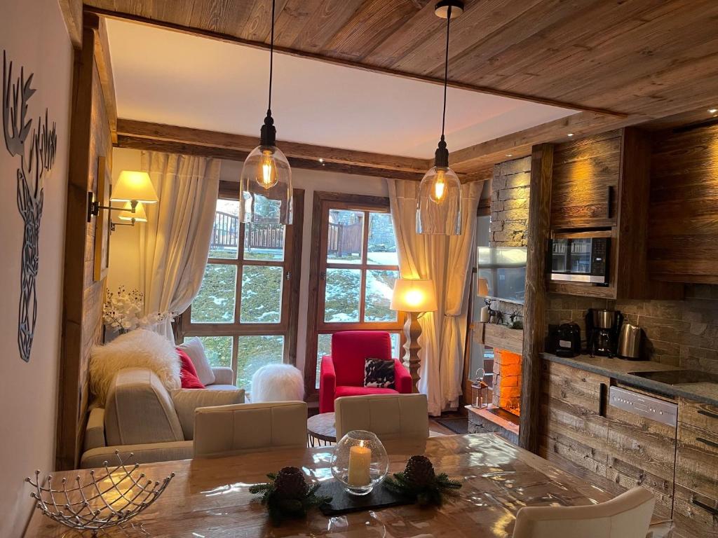une cuisine et un salon avec une table et des chaises dans l'établissement Arc 1950 appt luxe 2-4pers -skis aux pieds-SPA-piscines intérieure et extérieure-sauna-hammam, à Arc 1950