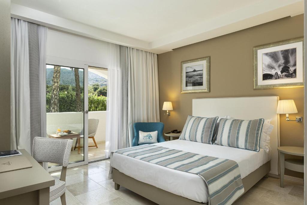 une chambre d'hôtel avec un lit et un balcon dans l'établissement Grand Hotel Cannigione, à Cannigione