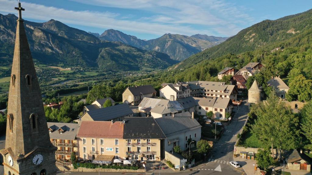 - une vue aérienne sur une petite ville avec une église et des montagnes dans l'établissement Les Fauvettes, à Saint-Léger-les-Mélèzes