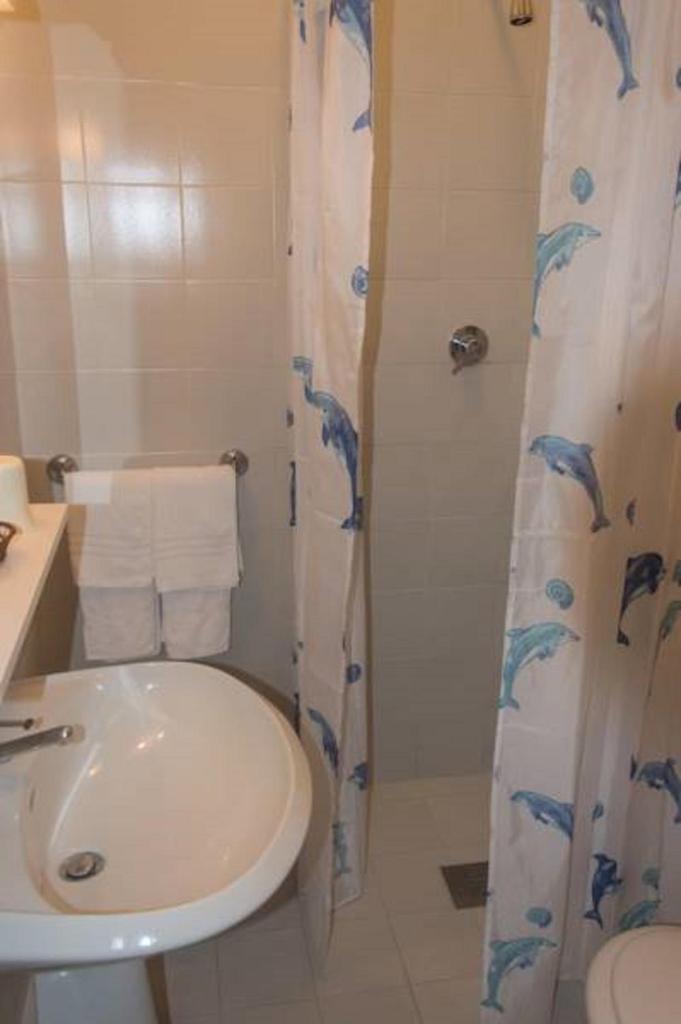 une salle de bain avec un lavabo, des toilettes et une douche dans l'établissement Pensione Villa Joli, à Lido di Jesolo 22 autres photos