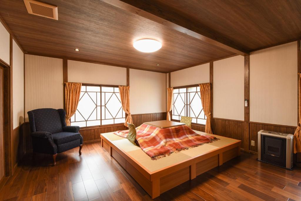 une chambre avec un lit et une chaise dans l'établissement Shinseikan, à Nishiwaga
