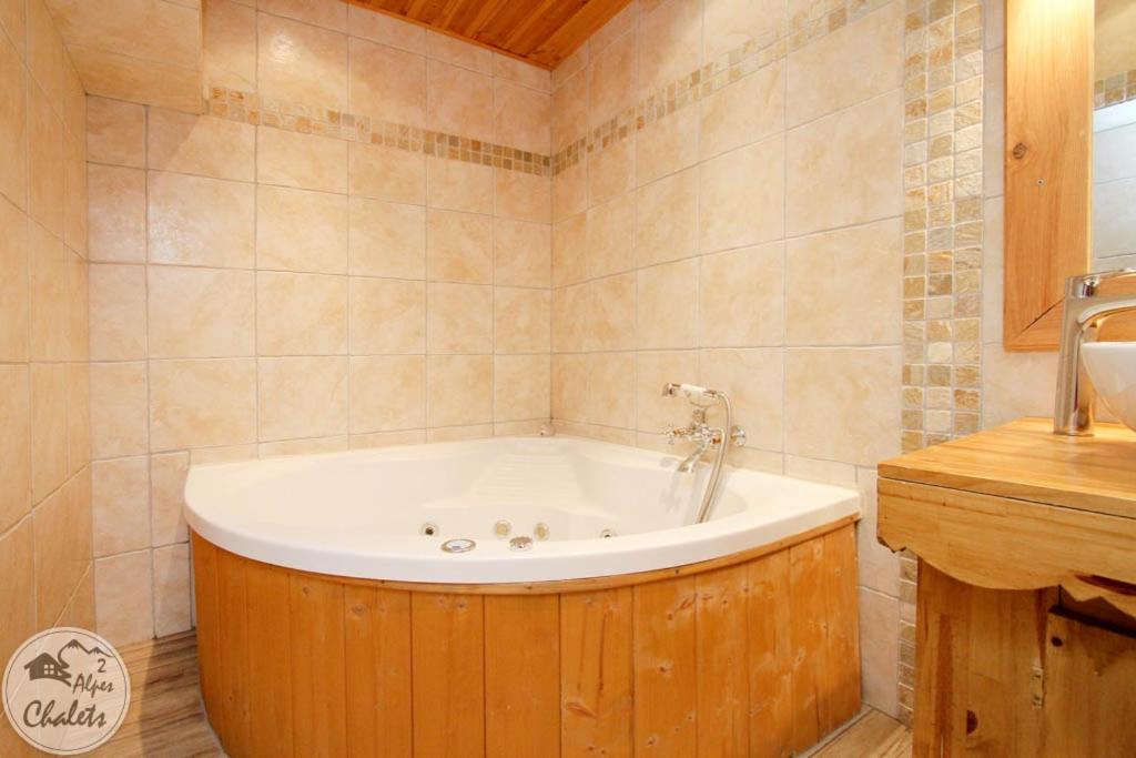 une salle de bain avec baignoire dans une chambre dans l'établissement 2AlpesChalets - Chalet Marie 1 - Standing et Sauna au pieds des pistes, à Les Deux Alpes 34 autres photos