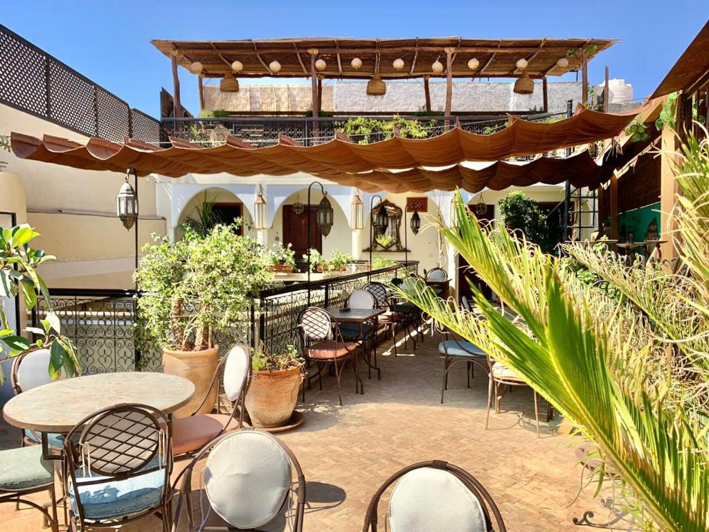 un patio extérieur avec tables, chaises et plantes dans l'établissement Color Safrà, à Marrakech