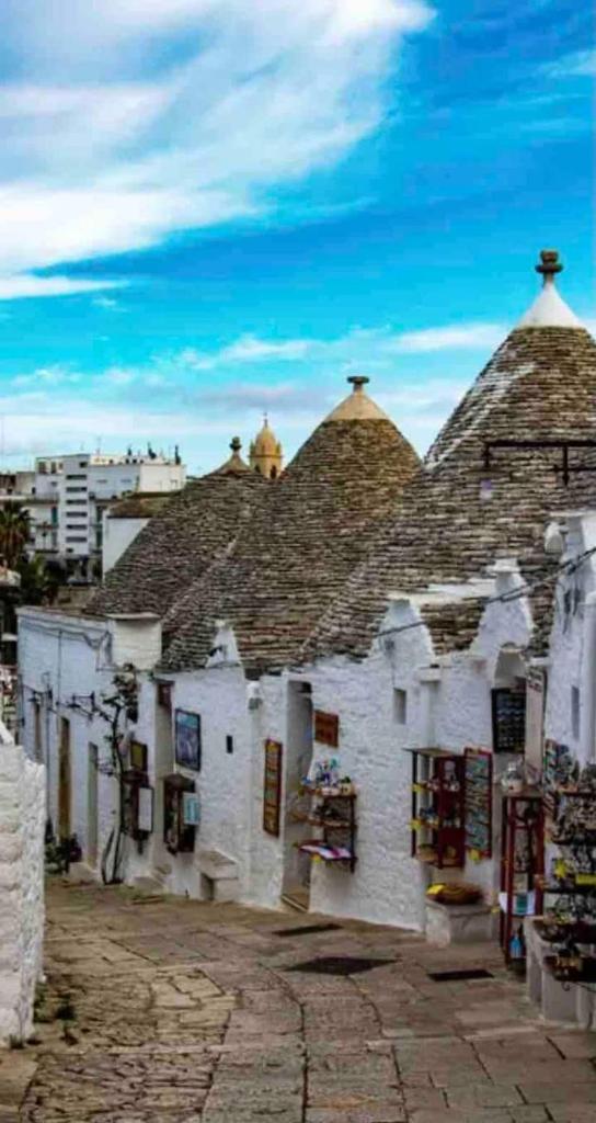 un vieux bâtiment blanc avec des toits pointus dans une rue dans l'établissement Pugliaholidayplus - VILLA CASSANO, à Polignano a Mare 33 autres photos