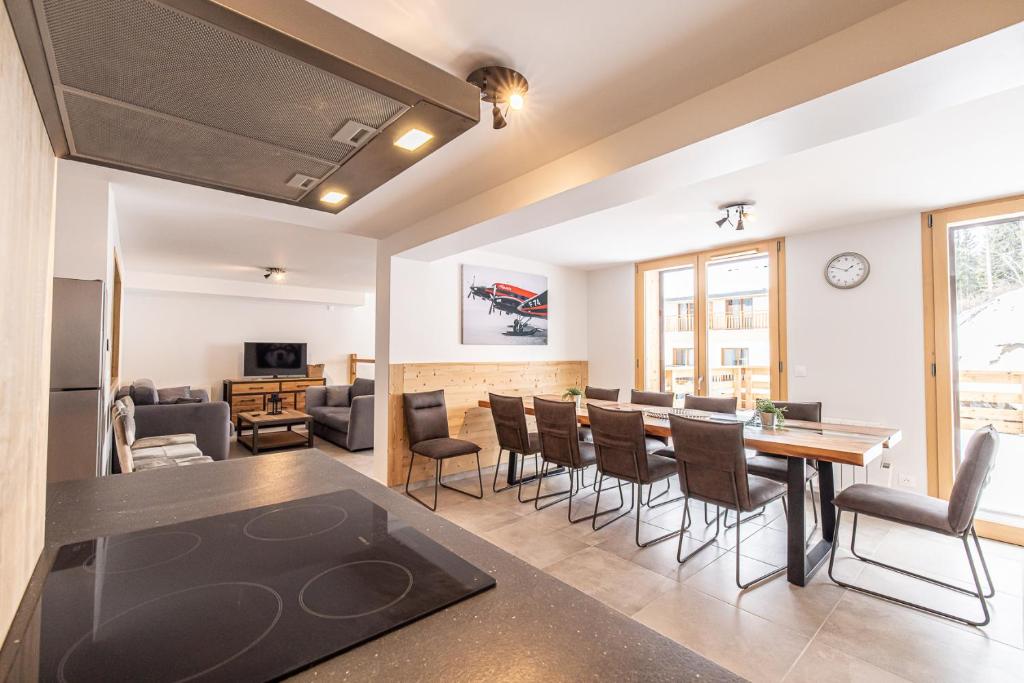 une salle à manger et un salon avec une table et des chaises dans l'établissement Le Loft Alpin, à Oz