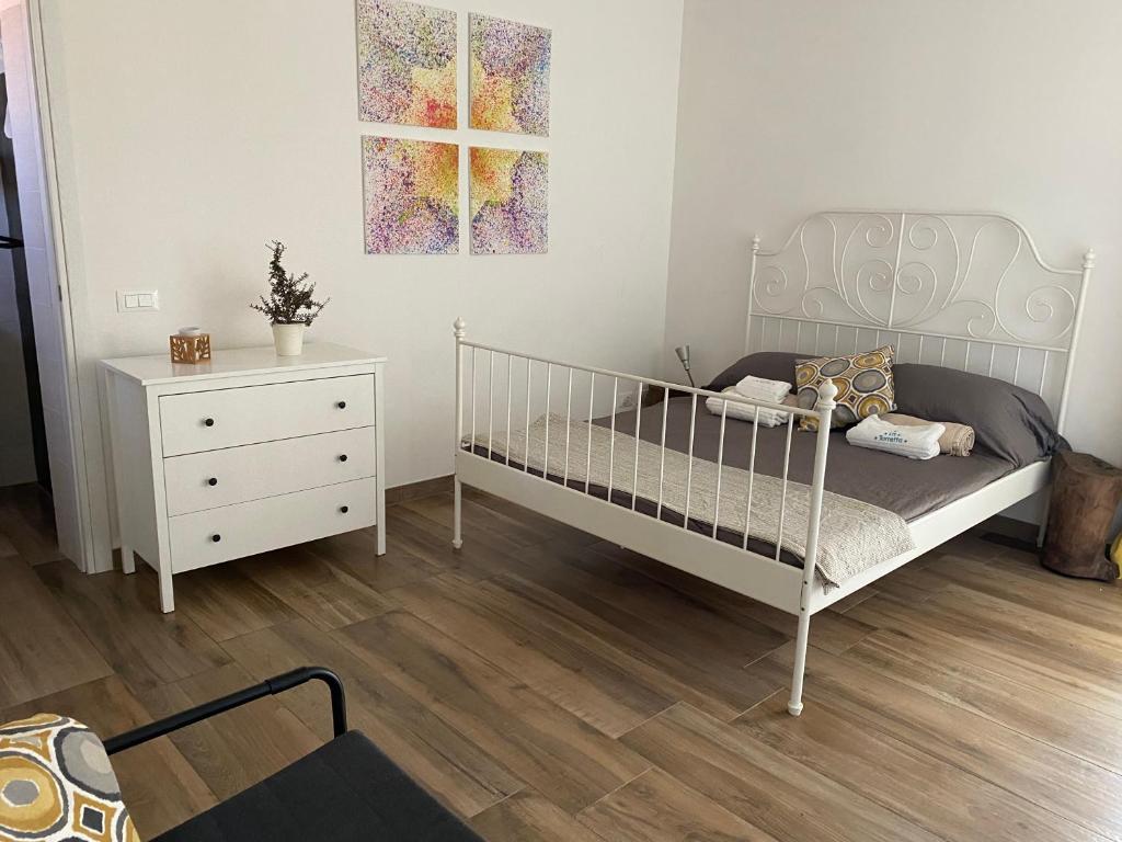 une chambre avec un lit blanc et une commode dans l'établissement Pugliaholidayplus - LA TORRETTA, à Polignano a Mare