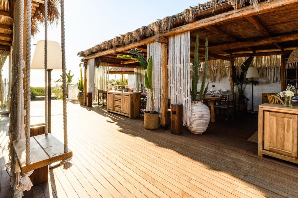 une terrasse en bois avec une table et un vase dans l'établissement Cumeja Beach Club & Hotel, à Baia Domizia