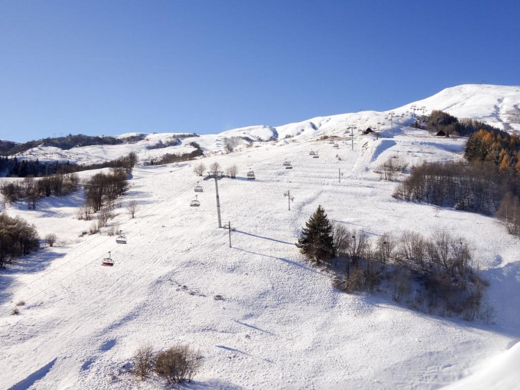une piste de ski enneigée avec une remontée mécanique. dans l'établissement Studio Lunik Orion-32 by Interhome, au Corbier
