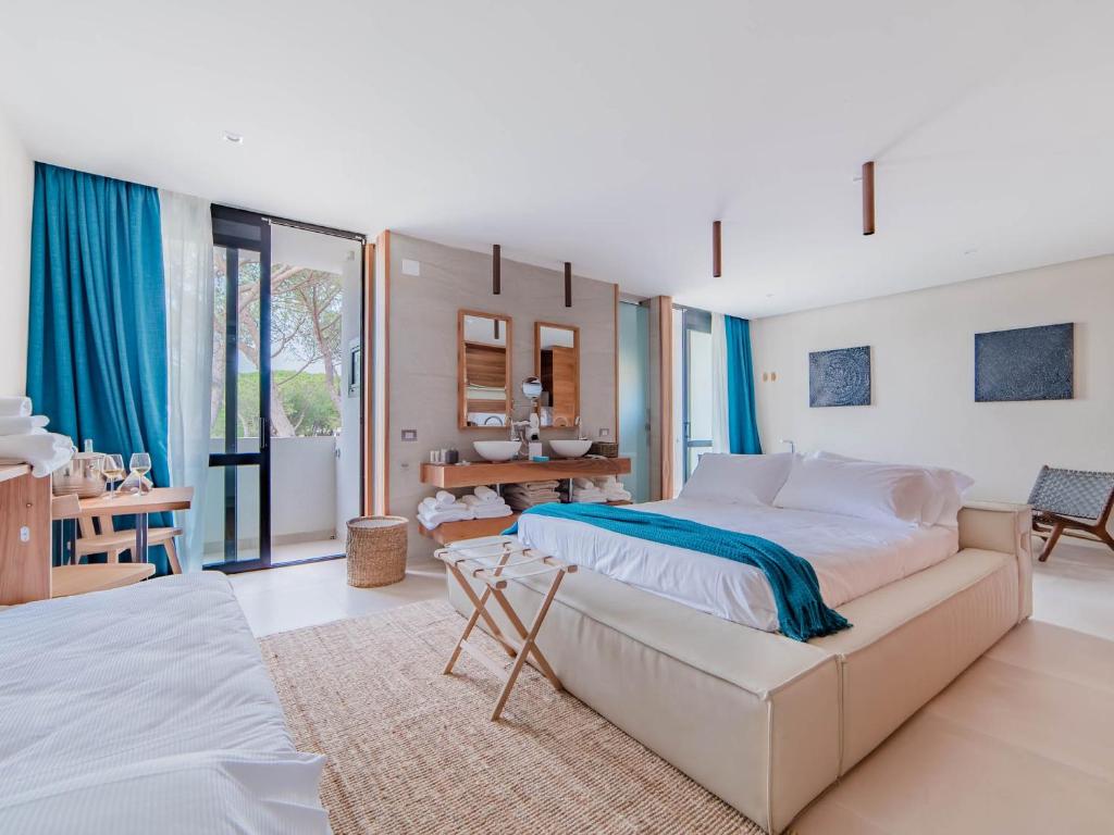 une chambre avec un grand lit et une grande fenêtre dans l'établissement Cumeja Beach Club & Hotel, à Baia Domizia