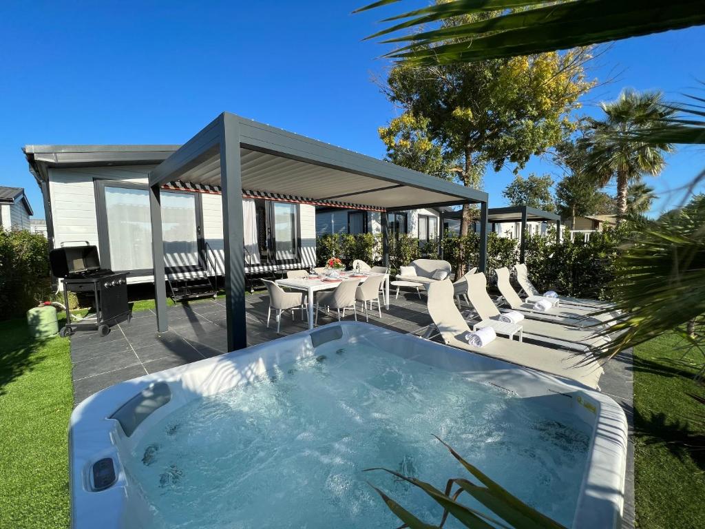 - un bain à remous dans une cour avec des chaises et des tables dans l'établissement Holiday Marina Resort, à Grimaud