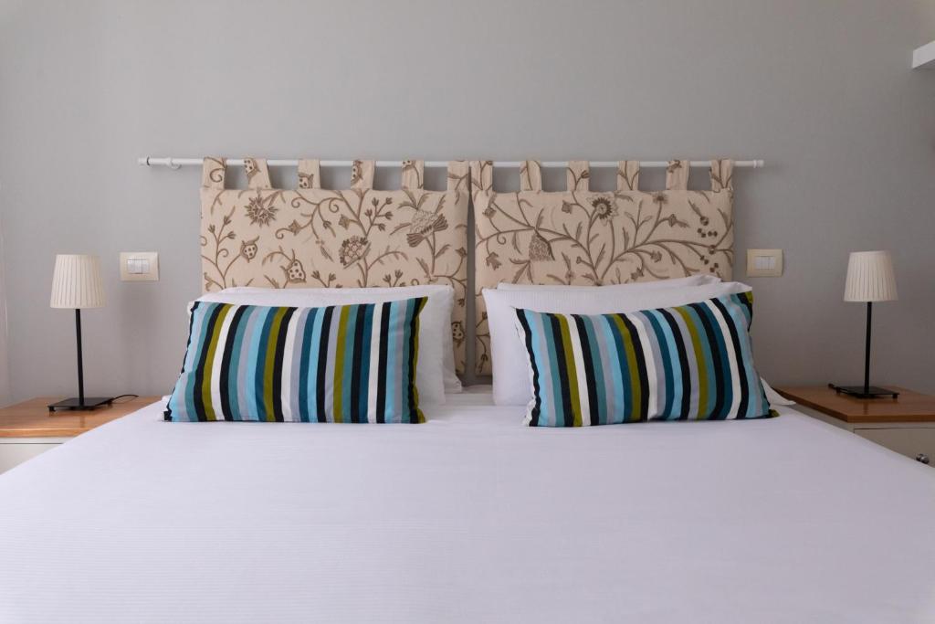 une chambre avec un lit blanc avec deux oreillers dans l'établissement Lido Azzurro, à Numana