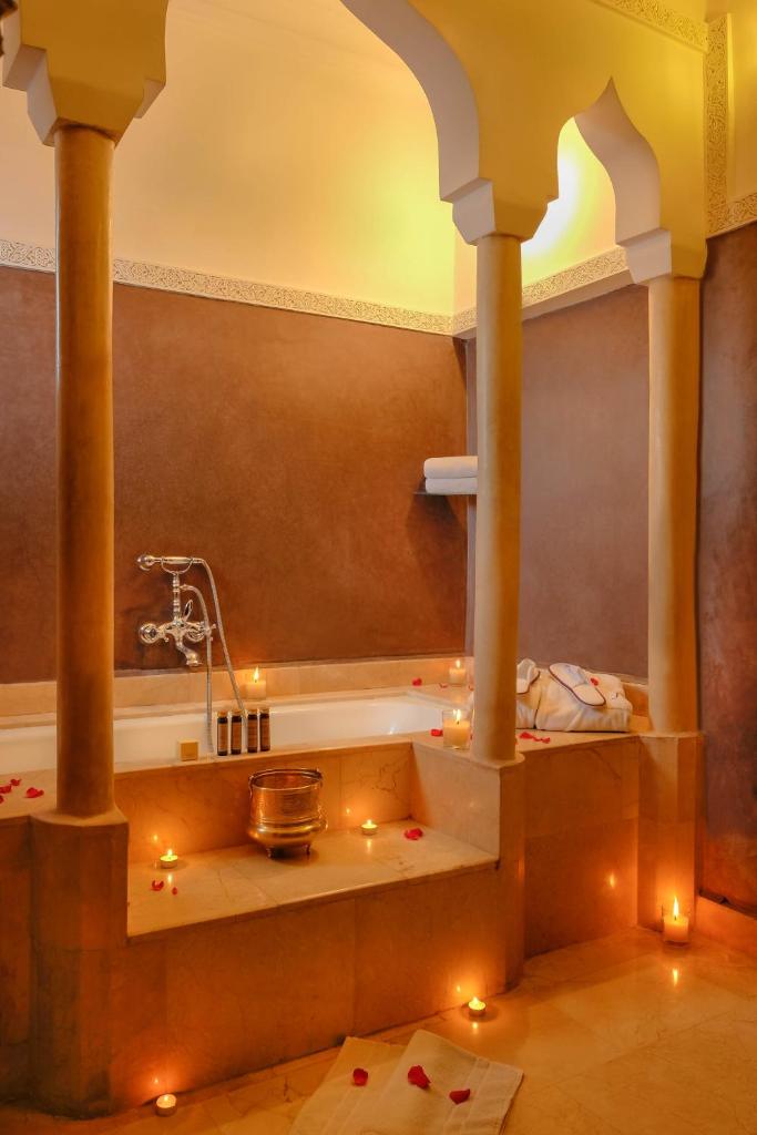 une salle de bain avec une baignoire avec des bougies dedans dans l'établissement Riad Marrakech By Hivernage, à Marrakech 37 autres photos