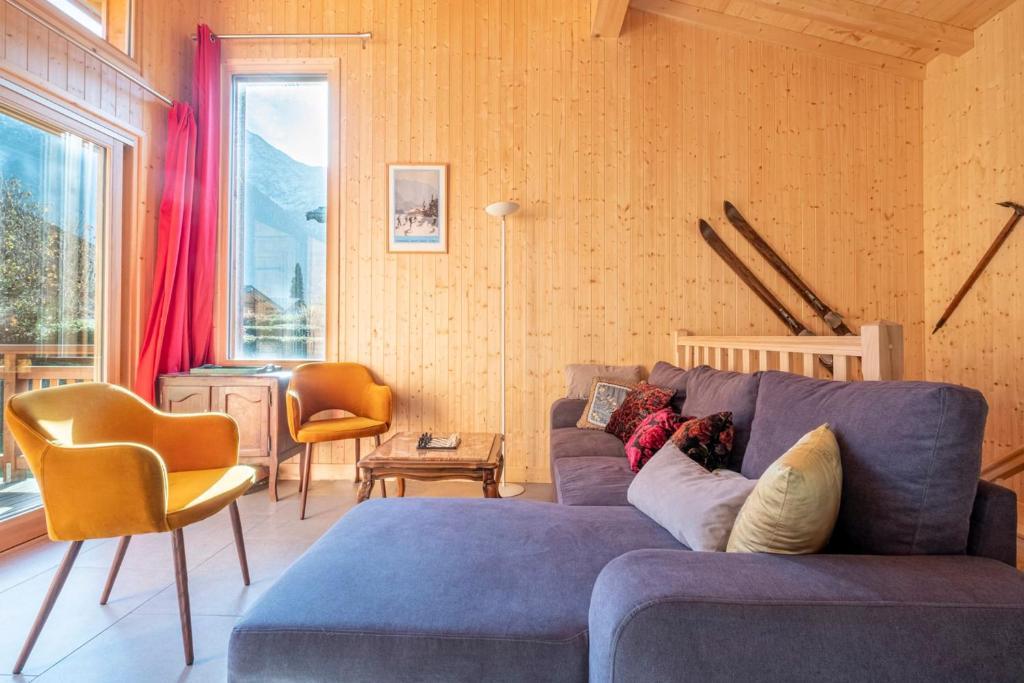 un salon avec un canapé bleu et des chaises dans l'établissement Family Cottage With Balcony In Chamonix, à Chamonix-Mont-Blanc