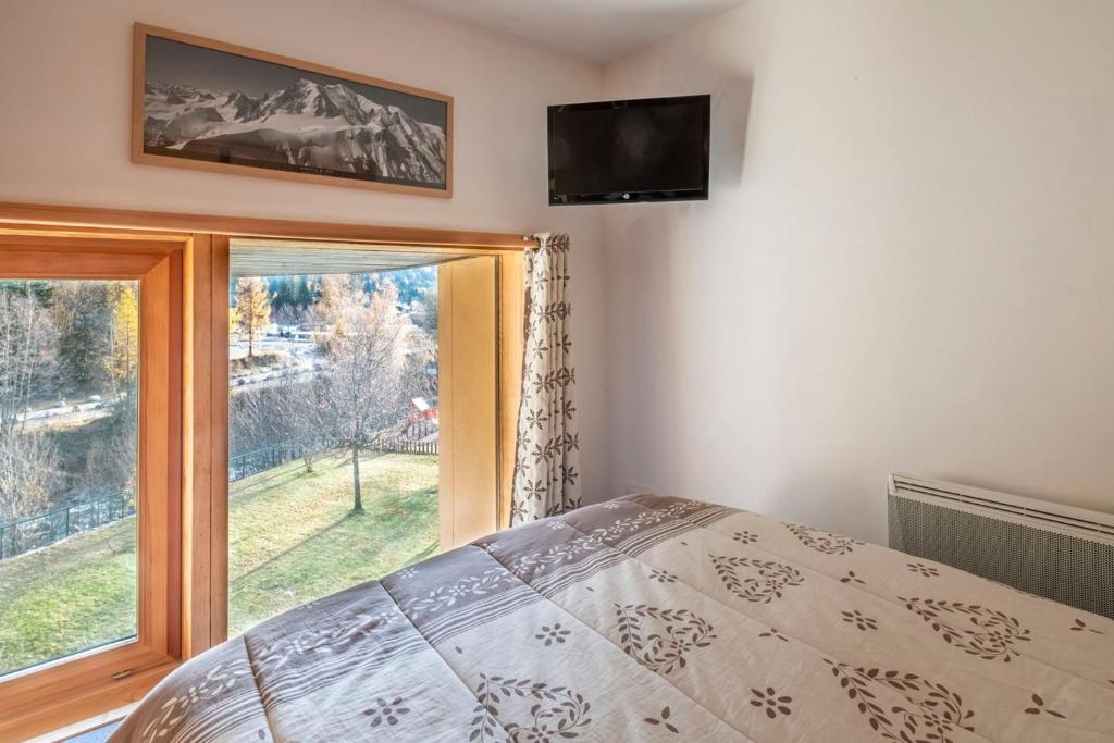 une chambre avec un lit et une grande fenêtre dans l'établissement Bel Apt Near The Slopes Argentiere, à Chamonix-Mont-Blanc 6 autres photos
