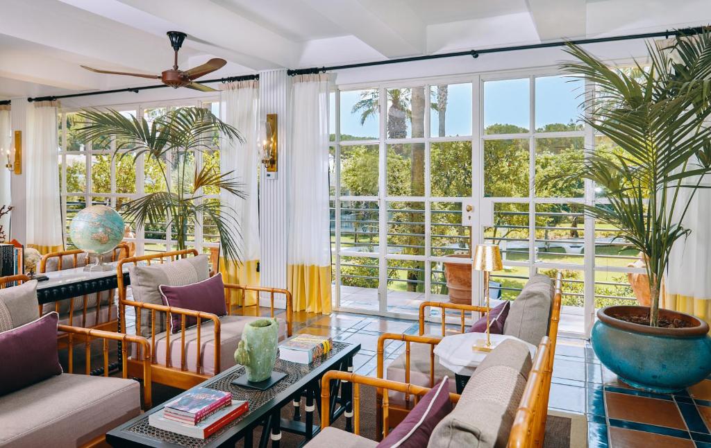 Elle comprend un salon meublé et une grande fenêtre. dans l'établissement Boutique Hotel Esplanade, à Paestum