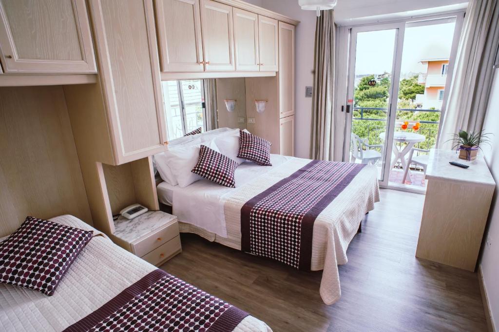 une chambre d'hôtel avec deux lits et une fenêtre dans l'établissement Hotel Margherita, à Lido di Jesolo