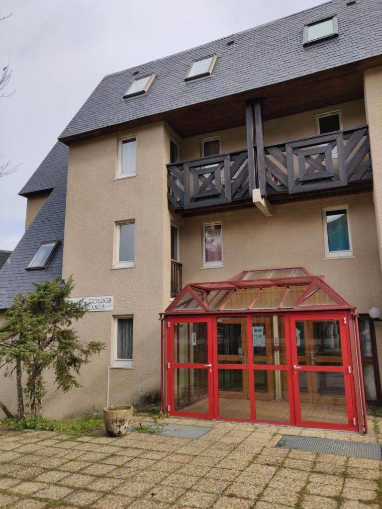 une structure rouge devant un bâtiment dans l'établissement Appartement neuf 4-6 pers. aux pieds des pistes, à Génos