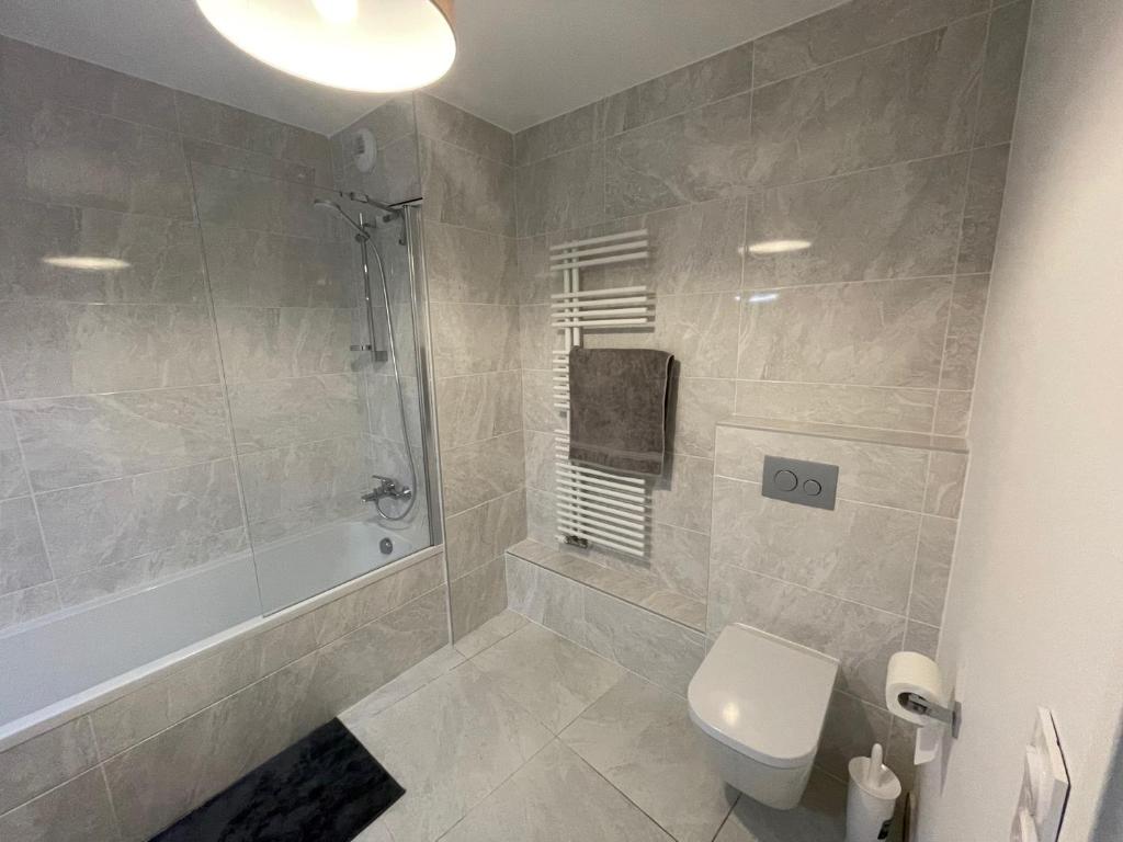 La salle de bains est pourvue d'une douche, de toilettes et d'une baignoire. dans l'établissement Apartment Gallery Mont Blanc Saint-Gervais-Les-Bains, à Saint-Gervais-les-Bains 11 autres photos