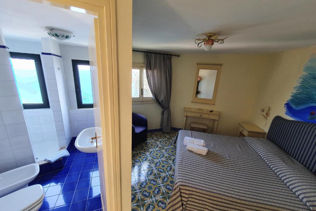 une chambre avec un lit et une salle de bain avec un lavabo dans l'établissement Hotel Torre Saracena, à Praiano