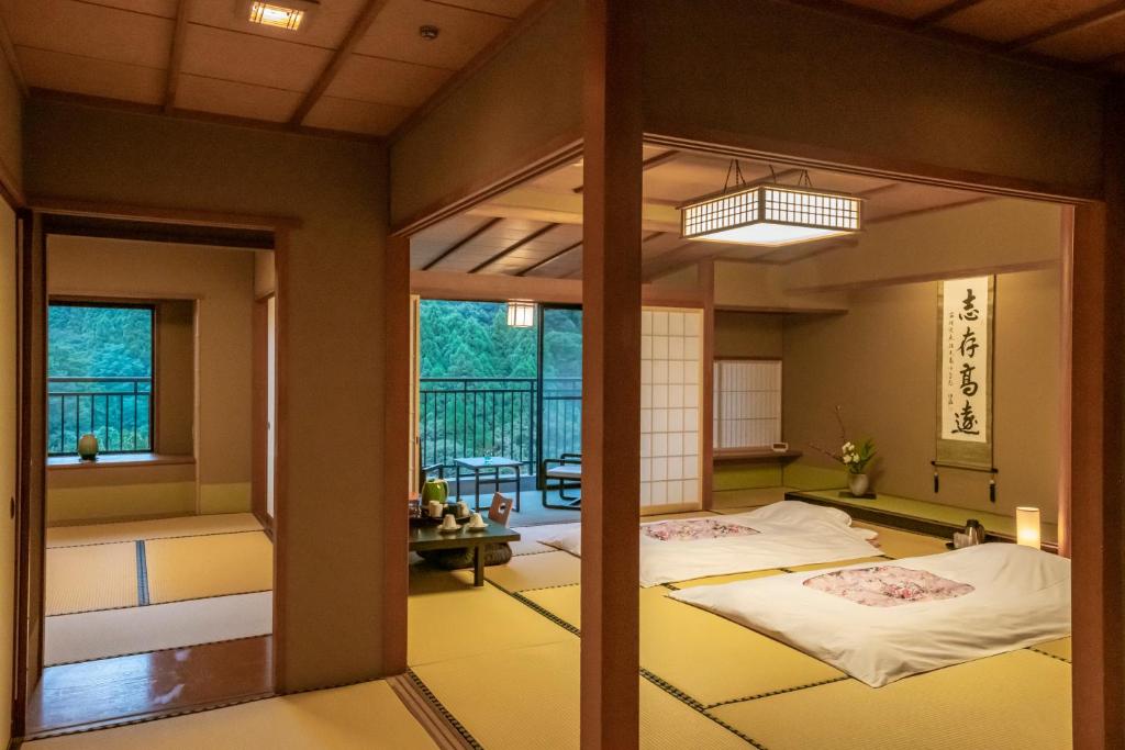 Cette chambre comprend 2 lits et un miroir. dans l'établissement Yamanaka Onsen Hanatsubaki, à Kaga 37 autres photos