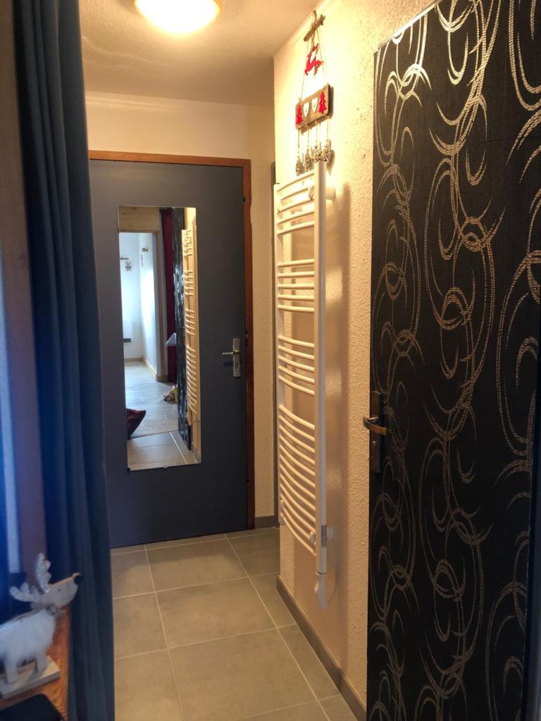 Cette chambre dispose d'une porte et d'un couloir avec un miroir. dans l'établissement Petit appartement Labellisé Les 2 Alpes résidence Arc en Ciel télésiège Petite Aiguille, à Les Deux Alpes