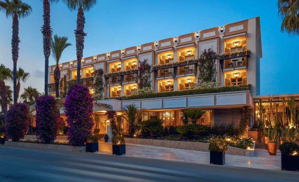 - une vue sur l'extérieur d'un hôtel avec des palmiers dans l'établissement Boutique Hotel Esplanade, à Paestum