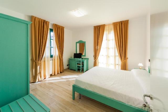 - une chambre avec un grand lit dans une pièce dotée de fenêtres dans l'établissement Agriturismo Le Meridiane, à Borgomaro
