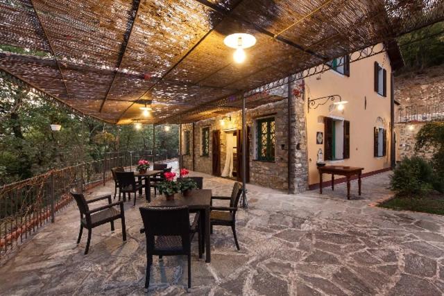 un patio avec une table et des chaises et un bâtiment dans l'établissement Agriturismo Le Meridiane, à Borgomaro