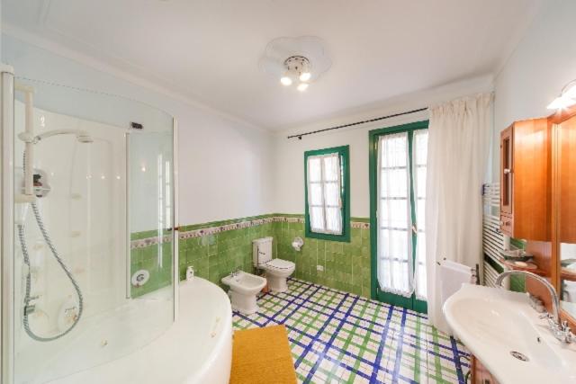 La salle de bains est pourvue d'une baignoire, d'une douche et de toilettes. dans l'établissement Agriturismo Le Meridiane, à Borgomaro